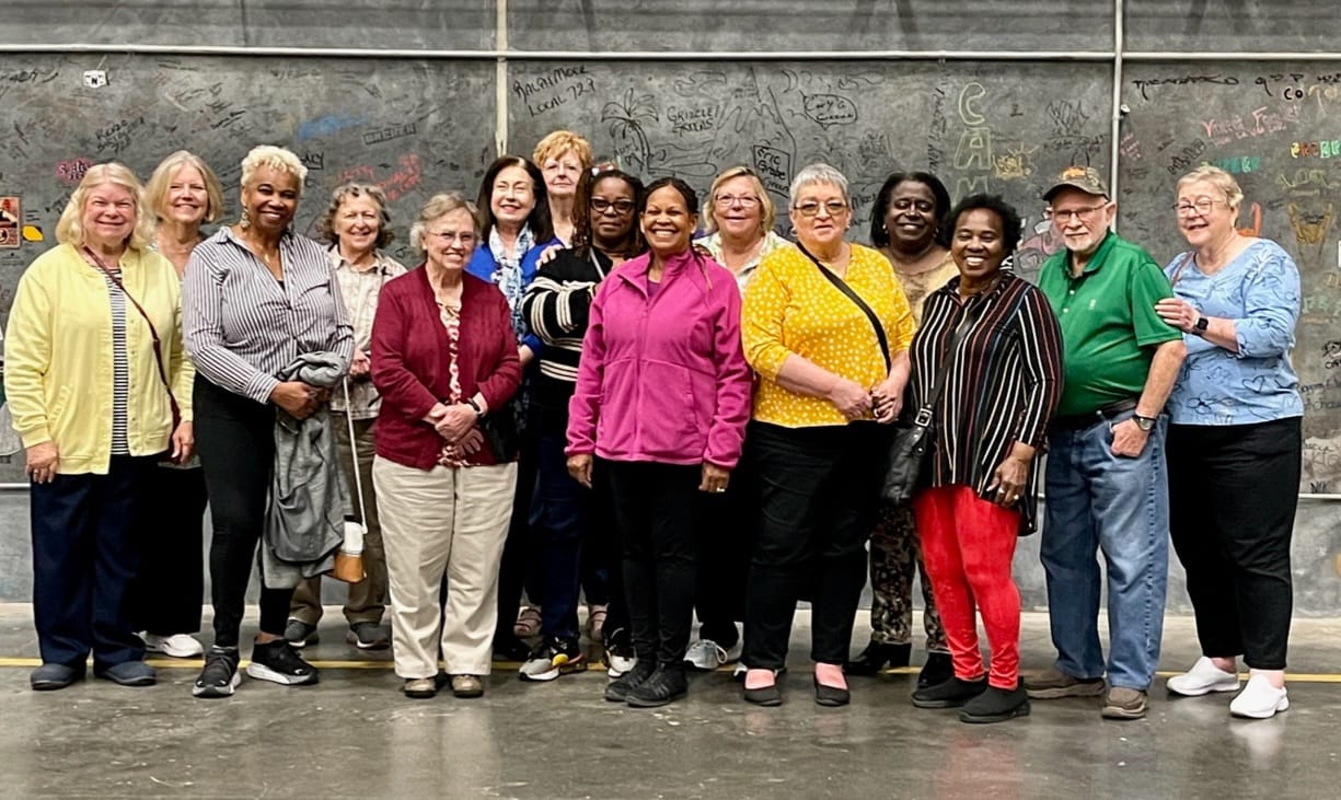 Group of older adults in front of a concrete wall at Trilith Studios.